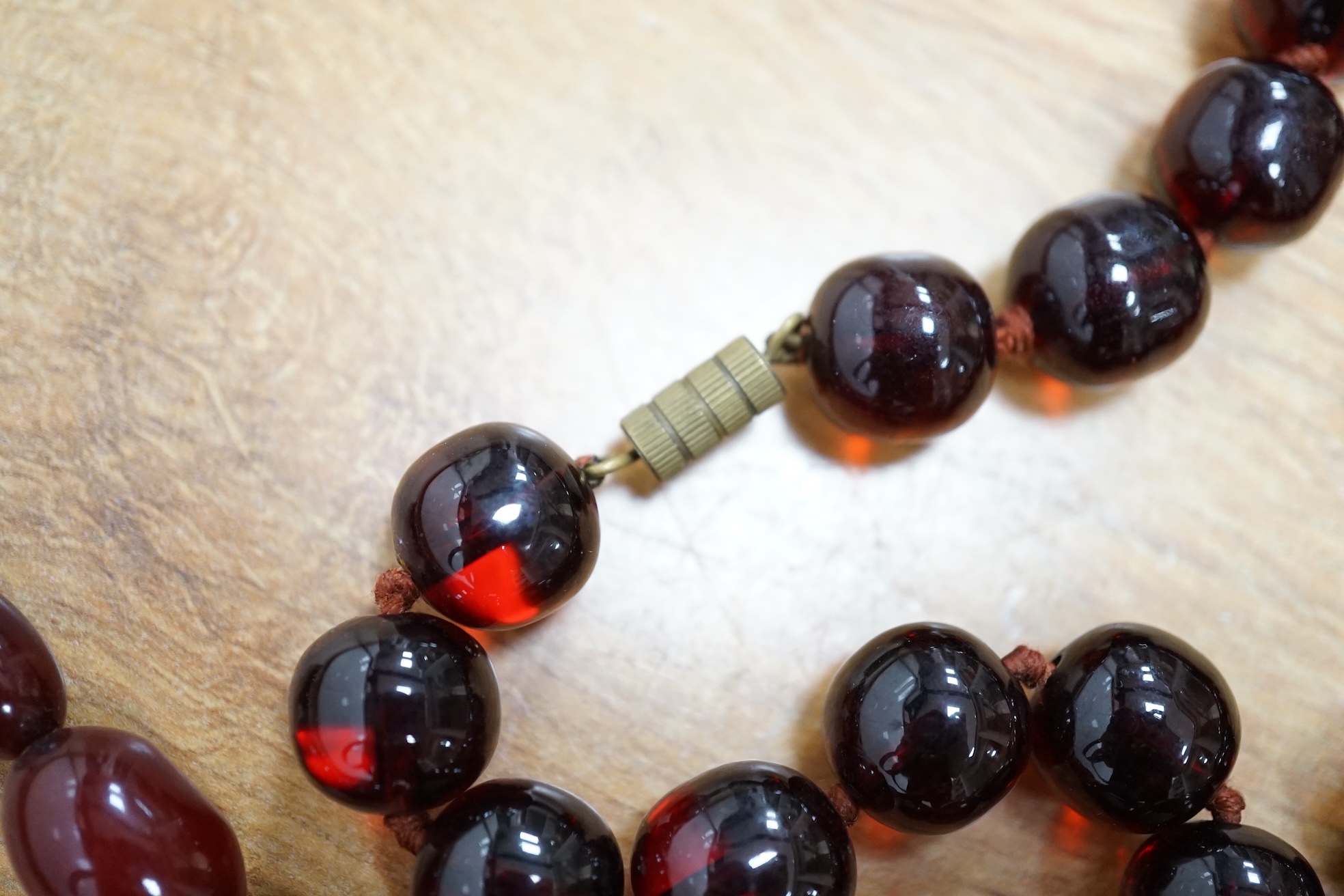 Two single strand simulated cherry amber bead necklaces, including one graduated string, 38cm, gross weight 173 grams. Condition - fair